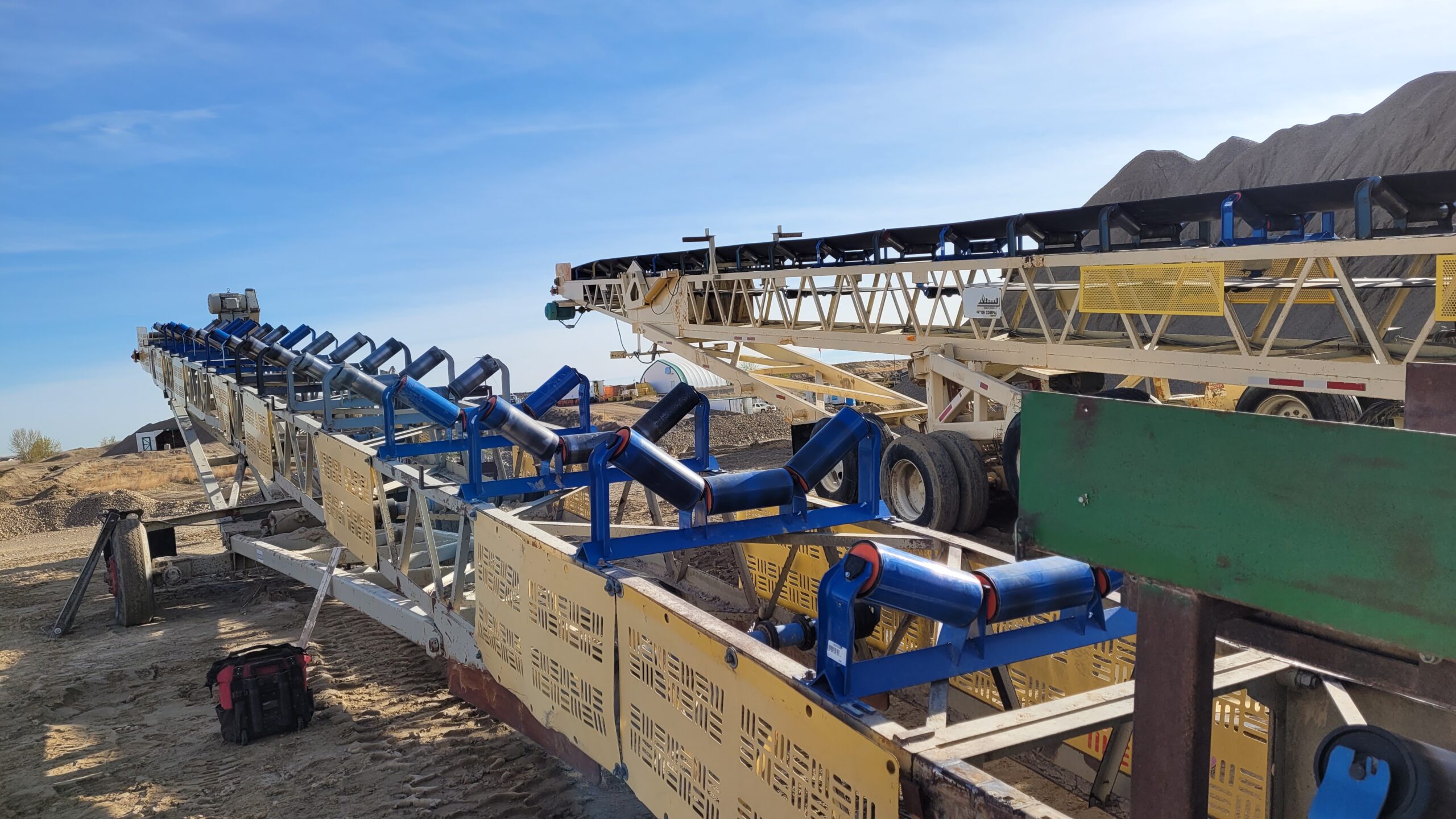 Yellow and blue trough idlers at a mining site