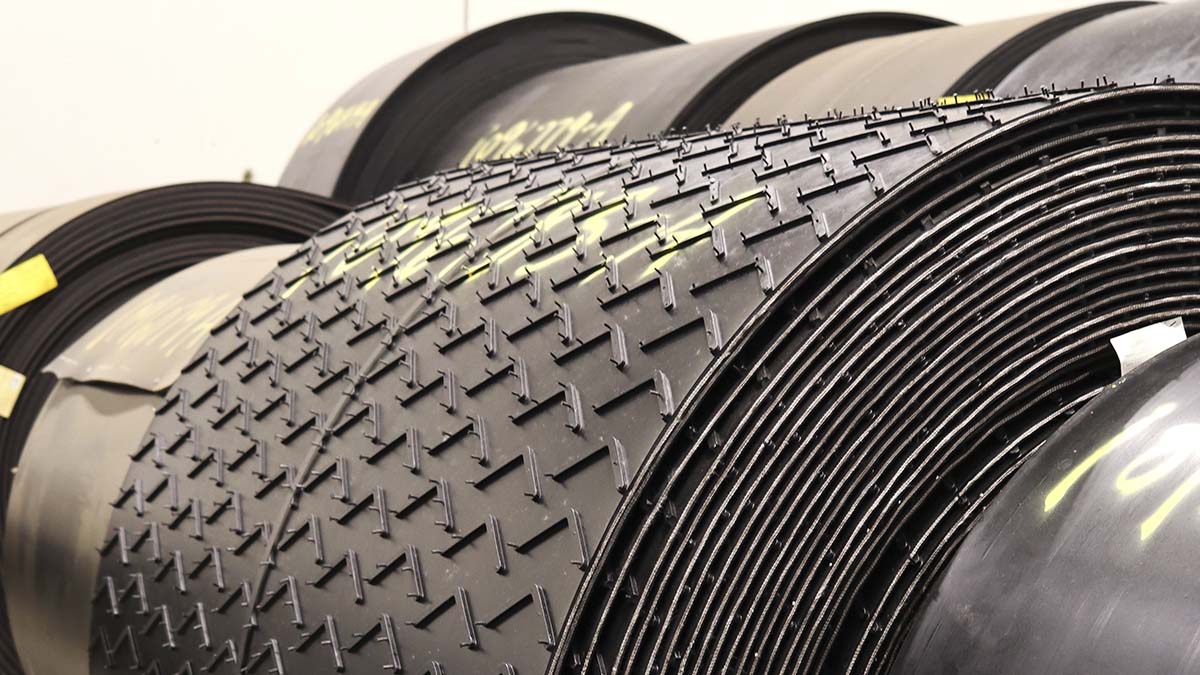 Treaded conveyor belt roll