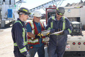Supervisor Three workers review construction plans