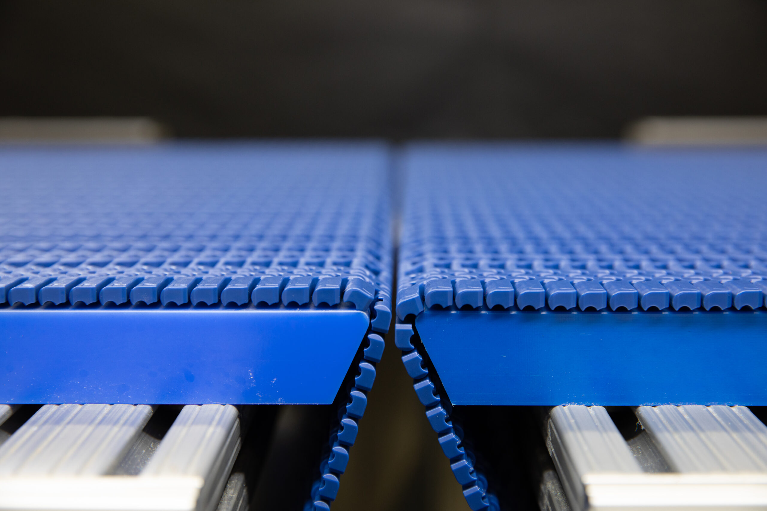 Lightweight Conveyor Belt Two workers working on installing a thermoplastic conveyor belt roll