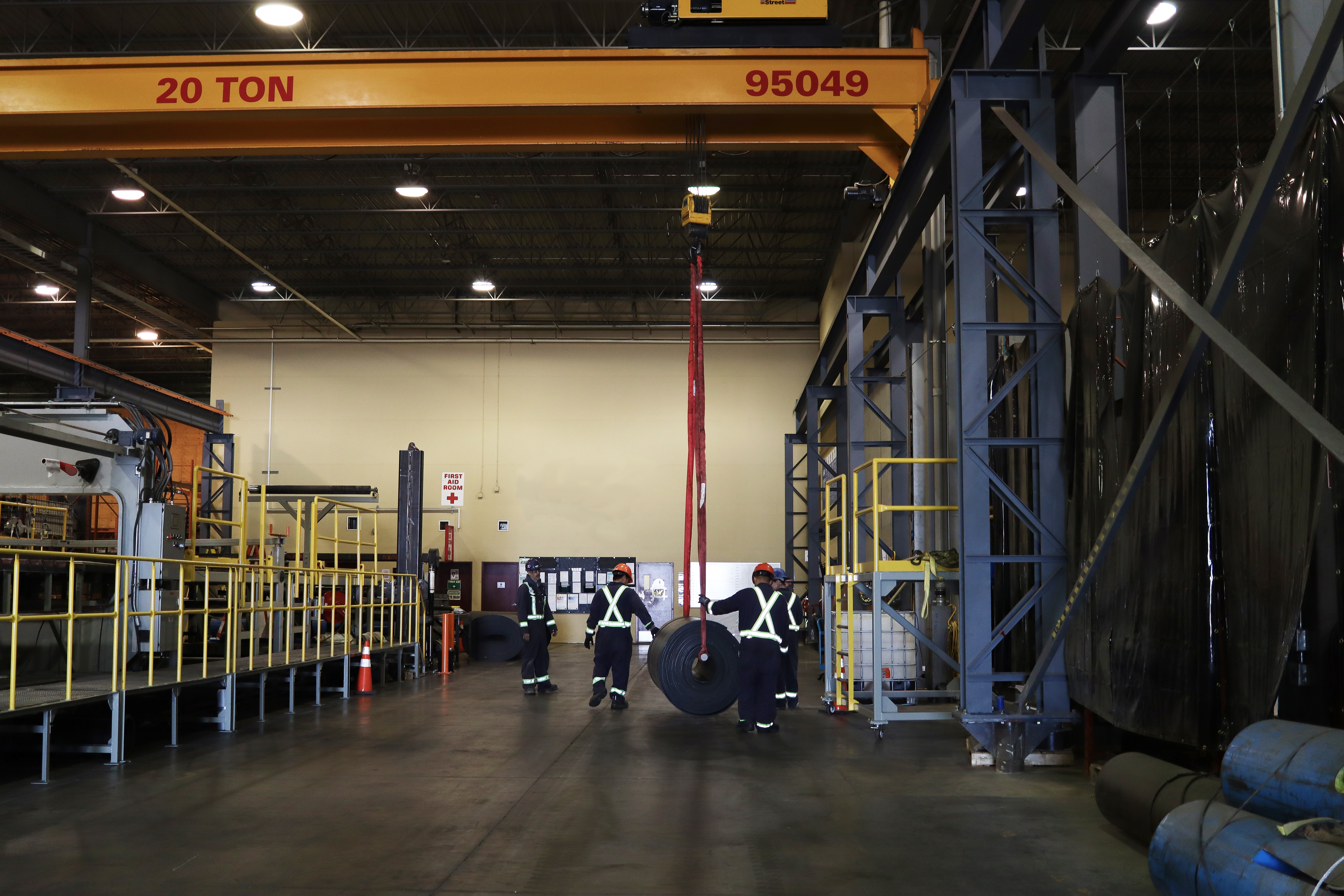 Workers transporting a conveyor belt within a warehouse